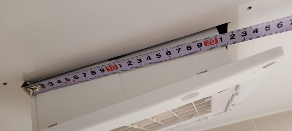 화장실 천장 환풍기 타공(구멍) 길이를 줄자로 측정하는 모습